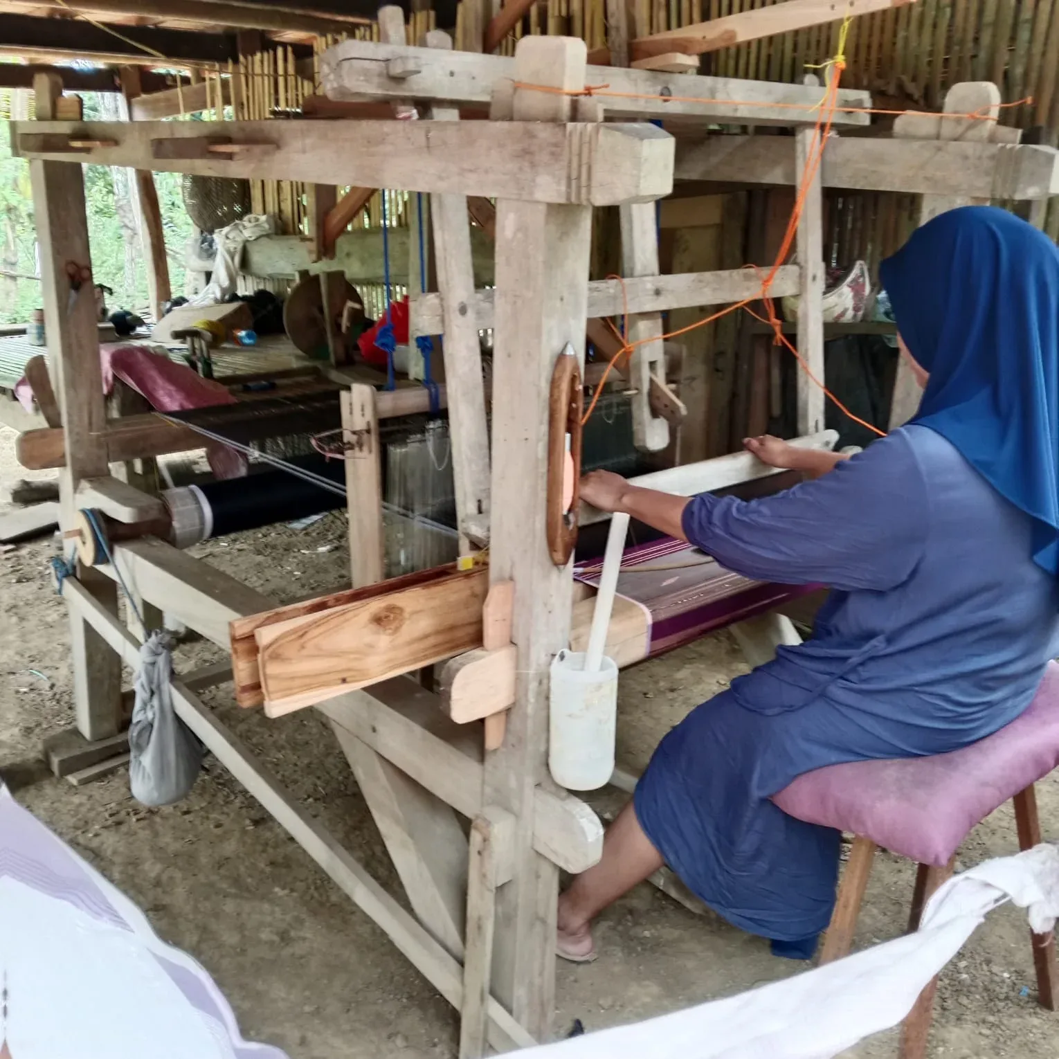Proses menenun kain tradisional yang mencerminkan keterampilan perempuan Bugis dalam menjaga tradisi sekaligus mendukung keberlanjutan ekonomi keluarga